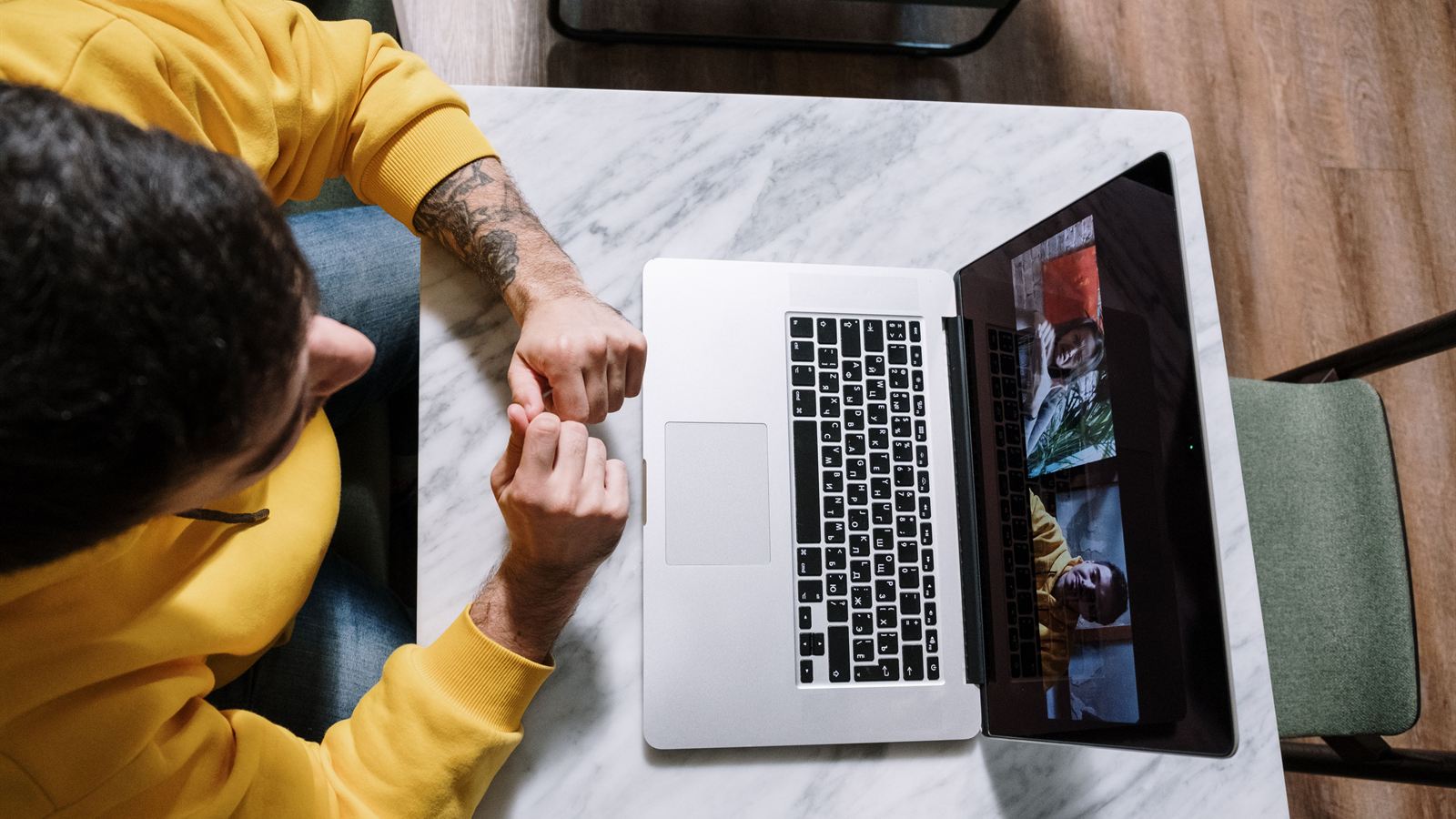 Overhead view of a man on a video call at his laptop